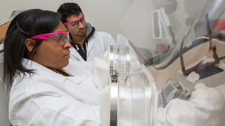 Two researchers working near a fume hood