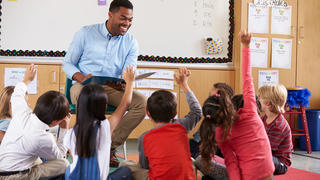 male teacher with students sitting