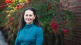 Dr. Rachelle Gold standing in front of flowers