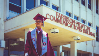 Graduate Jesse White standing in front of Farrison-Newton Communications Building