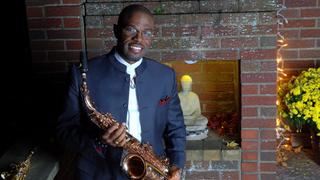 Antonio Hart, Grammy-nominated saxophonist, standing in front of fireplace