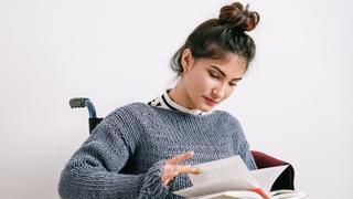 Student in wheelchair reading a book