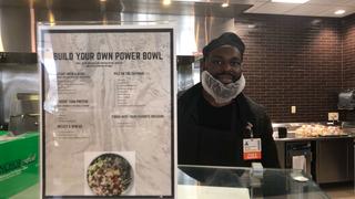 Cook standing behind counter with menu in foreground