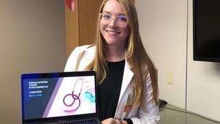 Student scientist holding laptop with presentation