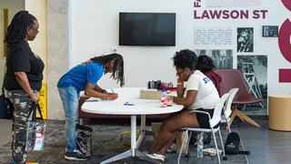 Students signing a log at a table