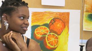 NCCU student looking off to the side, with art pieces in the background