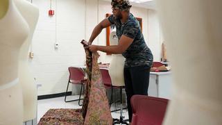 A student working on a dress design