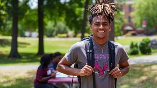 Male NCCU student on campus smiling.