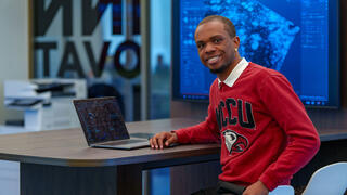 Student smiling with laptop on the table