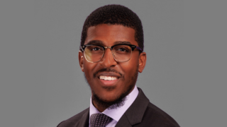 Dr. Ajamu Dillahunt-Holloway with suit and glasses