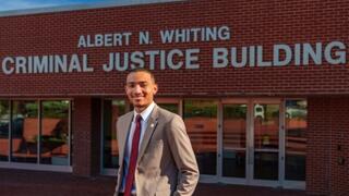 Male NCCU student standing in front of criminal justice building on NCCU Campus