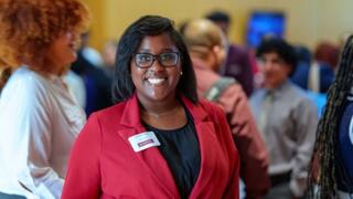 picture of african american woman standing in a room with people in the background