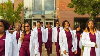 NCCU nursing students with maroon scrubs and white lab coats