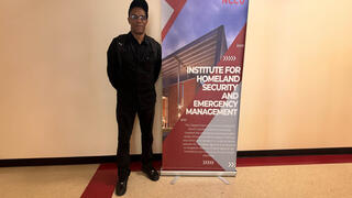 Dr. Muhammad standing next to sign