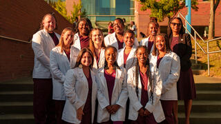 NCCU Nursing students in white coats smiling for the camera