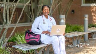 nurse sitting outside, with a laptop on lap