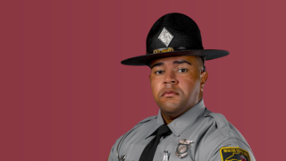 North Carolina state trooper Steven J. Perry in uniform with campaign hat against a maroon background.