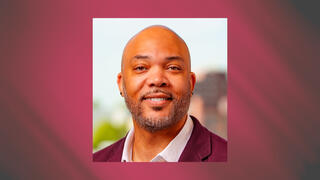 Professional portrait of Jason Armstrong smiling in a maroon blazer.