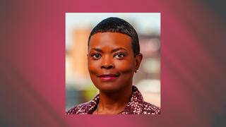 Professional portrait of Kimberly Williams with short natural hair wearing a textured blazer and pearl earrings.