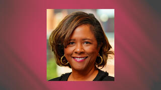 Executive headshot of Ramonda Kyser smiling in a black outfit with gold hoop earrings and highlighted hair.