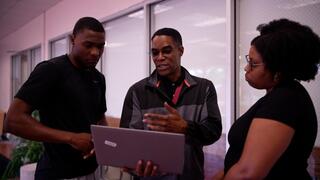 person holding a laptop, explaining something 