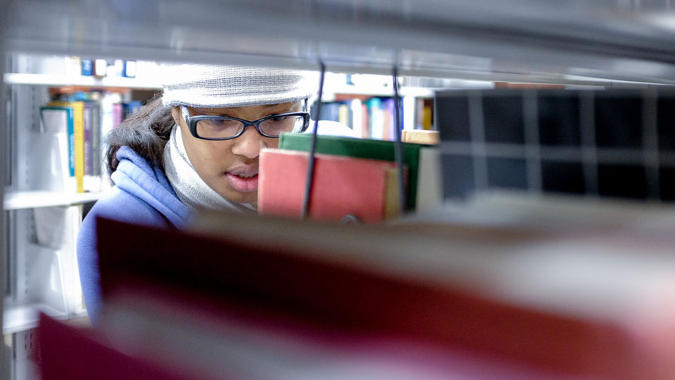 Student looking for books in library