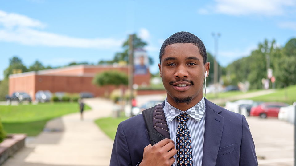 Student standing in front of Criminal Justice Building.