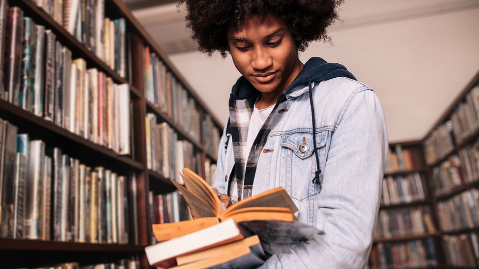 Student in library reading a book