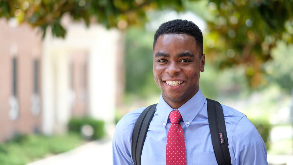 Student standing outside smiling at the camera.