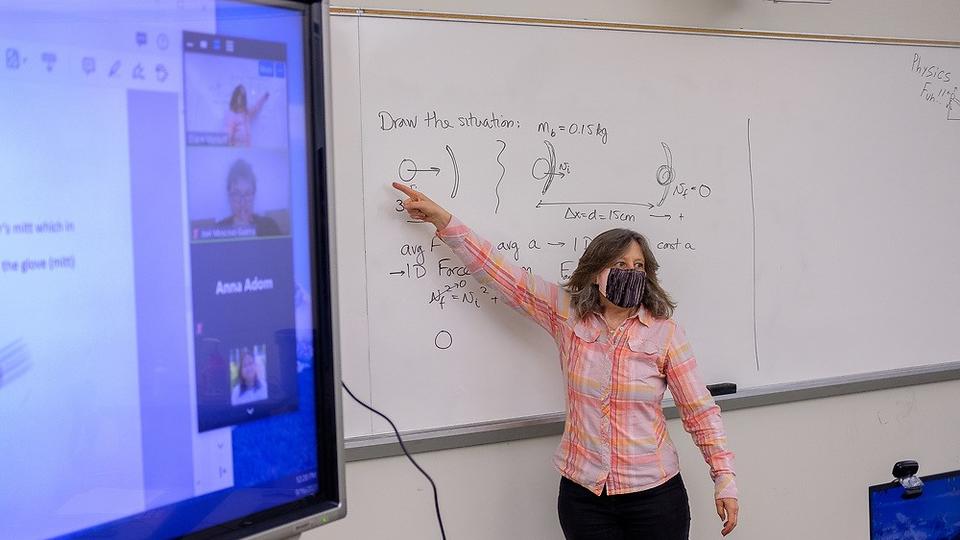 Professor is teaching on white board