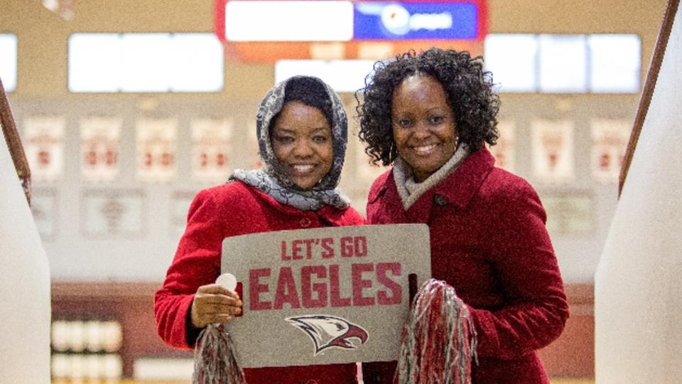 Two women posing with a "Lets Go Eagles!" sign.