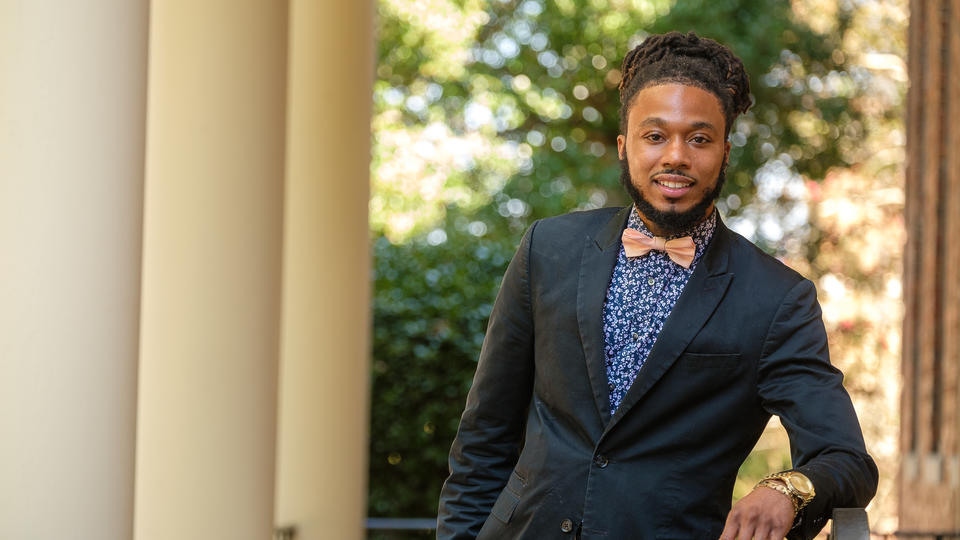 Student dressed up in suit and bowtie smiling