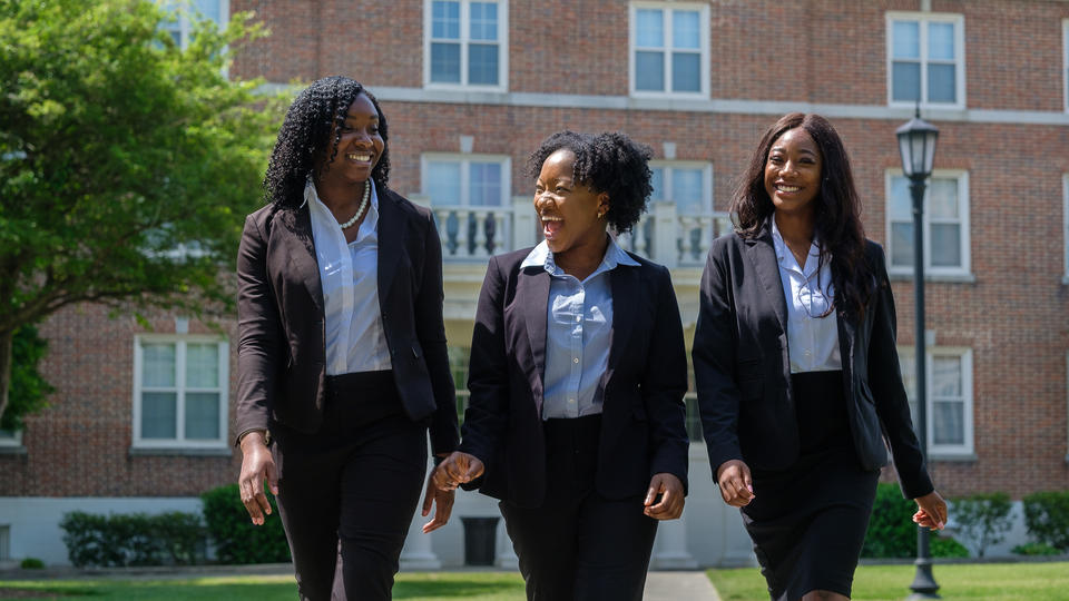 Students dressed up in suits smiling and walking