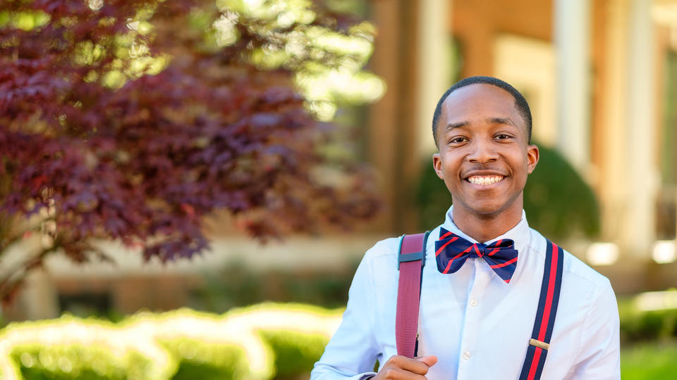 Student in bowtie and suspenders smiling