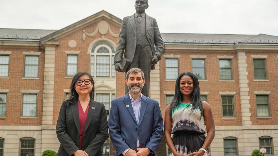 Three people in front of the Shepard Statue