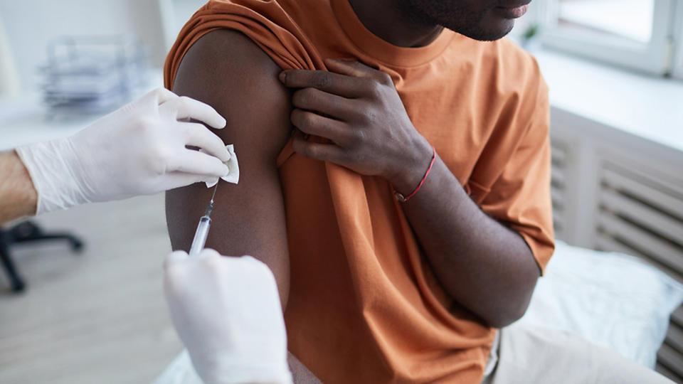 Close up of man receiving vaccine injection in arm