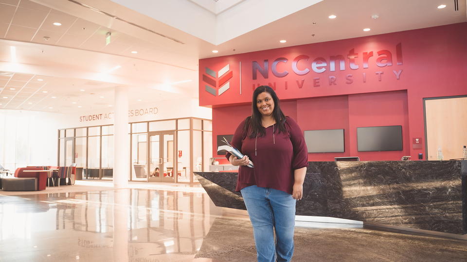 Student standing in a NCCU lobby