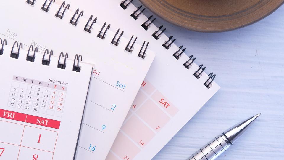 Calendars with pen and cup of coffee