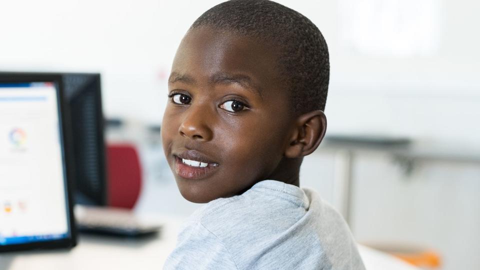 kid looking over his shoulder sitting in front