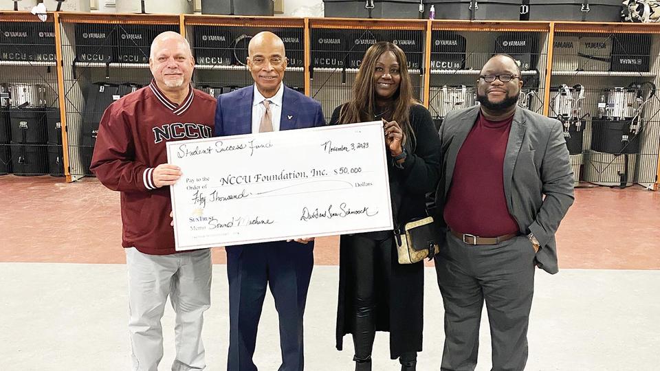 NCCU faculty holding up a check for the NCCU Foundation, Inc