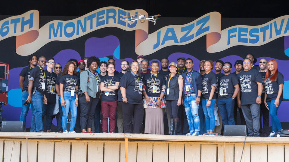 Monterrey Jazz Festival Attendees with banner behind them