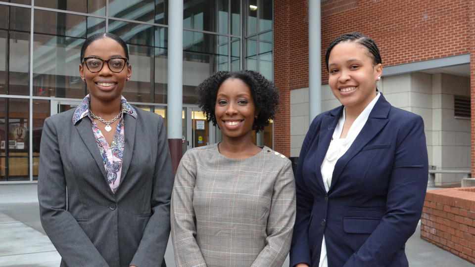 A group of law students standing in front of a buliding.