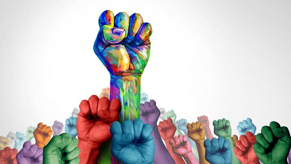 a field of multi-colored clenched fists pointing upwards 