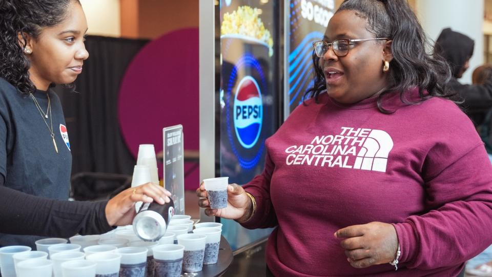 Student talking on Pepsi counter