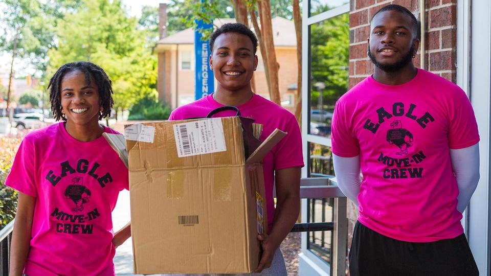Eagle move-in crew holding a box