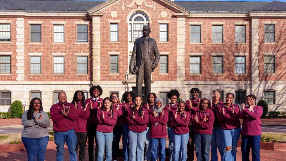 quiz team in front of the statue