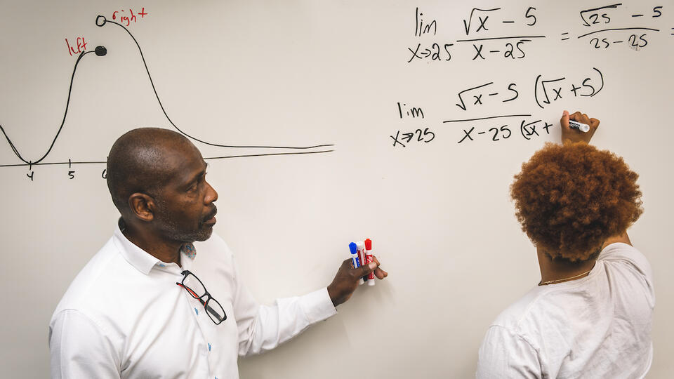 Dr. Frederick Johnson helps student with mathematics equation