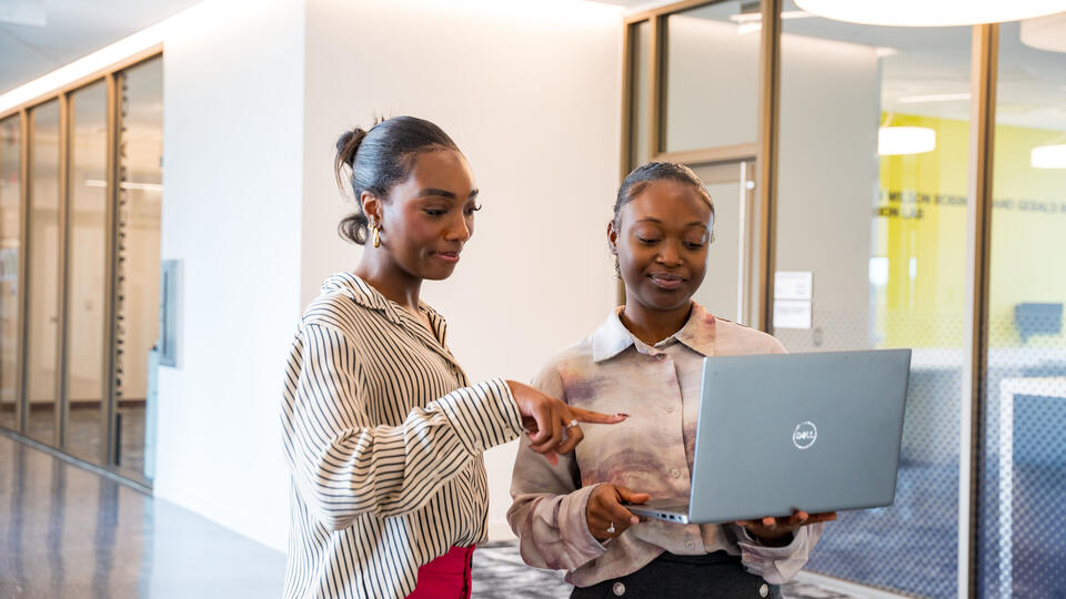 Two girls looking a laptop