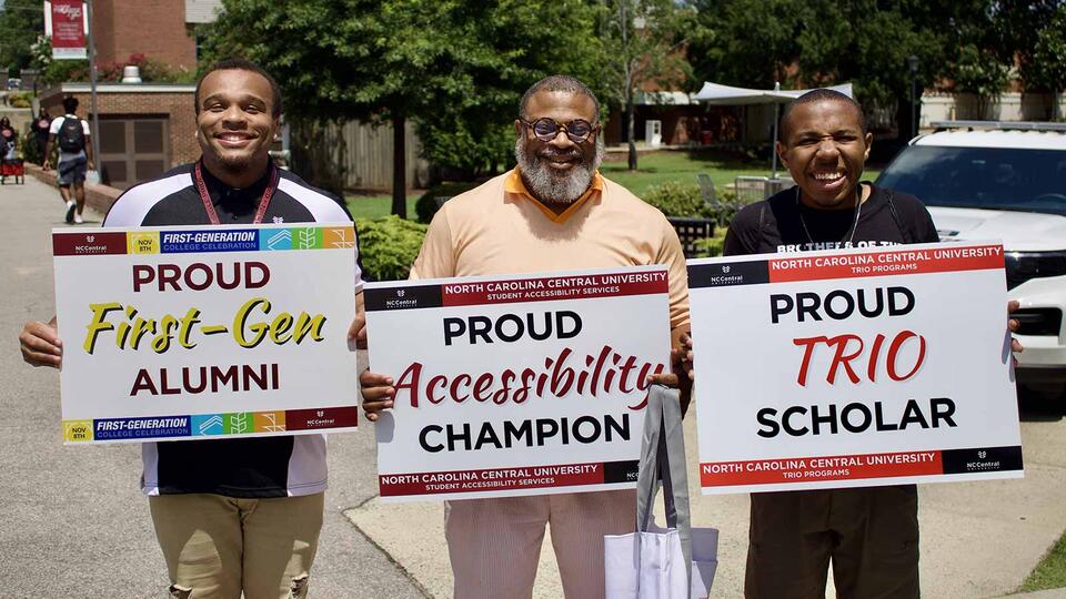 members of the first gen team holding up signs