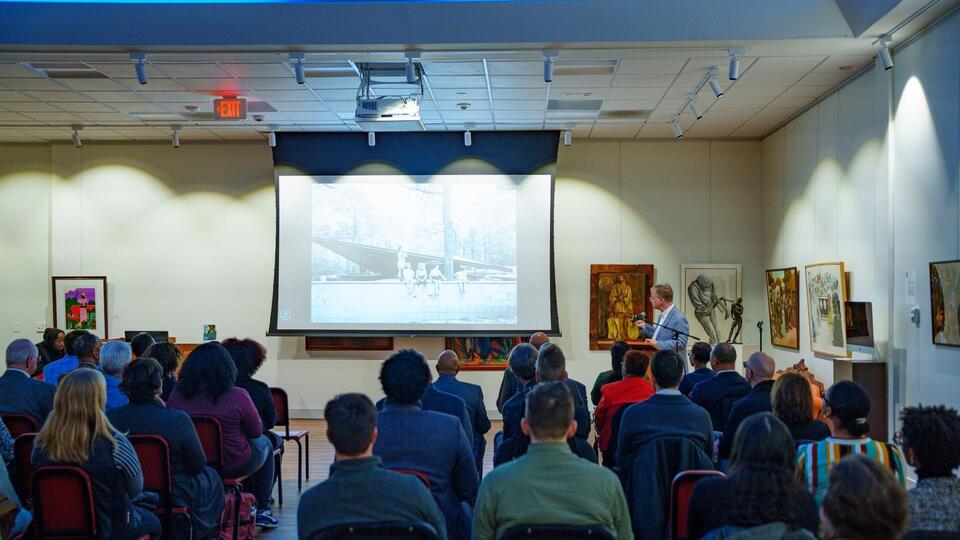 Audience seated facing a projection screen during an Eyrie Initiative event